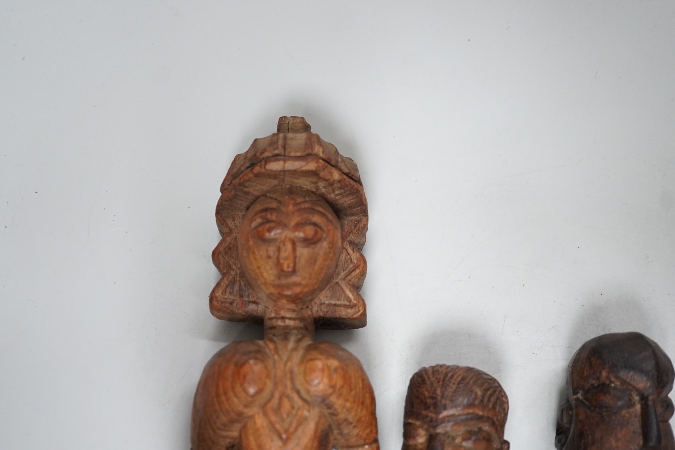 A carved teak terminal figure and two African tribal figures, largest 32cm long